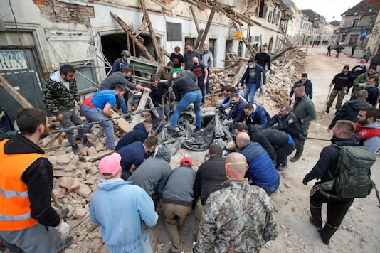 People help cleaning rubble next to damaged buildings in Petrinja, some 50 km from Zagreb, after the town was hit by an earthquake of the magnitude of 6.4 on December 29, 2020. (Damir SENCAR / AFP) People help cleaning rubble next to damaged buildings in Petrinja, some 50 km from Zagreb, after the town was hit by an earthquake of the magnitude of 6.4 on December 29, 2020. (Damir SENCAR / AFP)