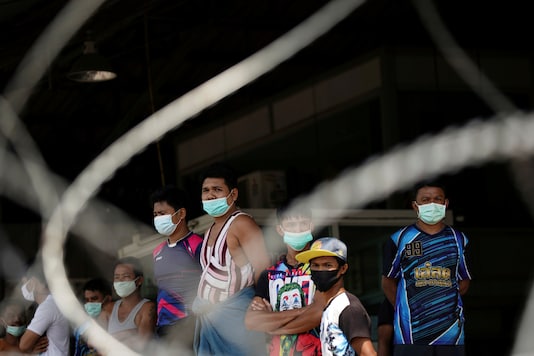 FILE PHOTO: Migrant workers stand in front of a closed shrimp market, amid the coronavirus disease (COVID-19) outbreak, in Samut Sakhon province, in Thailand, December 20, 2020. REUTERS/Athit Perawongmetha/File Photo FILE PHOTO: Migrant workers stand in front of a closed shrimp market, amid the coronavirus disease (COVID-19) outbreak, in Samut Sakhon province, in Thailand, December 20, 2020. REUTERS/Athit Perawongmetha/File Photo