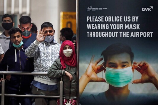 People wearing protective face masks wait for passengers to arrive at Chhatrapati Shivaji Maharaj International Airport after India cancelled all flights from the UK over fears of a new strain of coronavirus, in Mumbai on December 22. (File photo/Reuters))