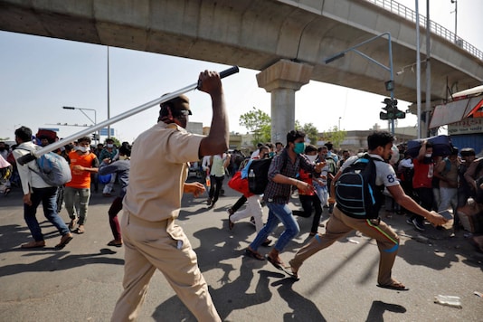 A policeman wields his baton to disperse migrant workers who were demanding train service to their home state of Bihar, after a limited reopening of India's giant rail network following a nearly seven-week lockdown to slow the spread of Covid-19), in Ahmedabad on May 17, 2020. (REUTERS/Amit Dave) A policeman wields his baton to disperse migrant workers who were demanding train service to their home state of Bihar, after a limited reopening of India's giant rail network following a nearly seven-week lockdown to slow the spread of Covid-19), in Ahmedabad on May 17, 2020. (REUTERS/Amit Dave)