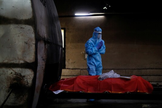 A relative pays his last respects to a family member who died from the coronavirus disease (COVID-19) as its draped body is prepared for cremation at a crematorium in New Delhi. (Reuters)