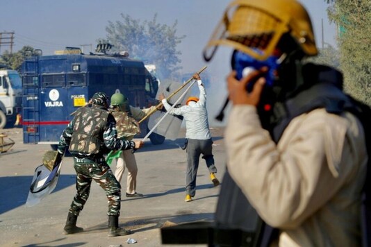 Policemen beat a protesting farmer, at the border between Delhi and Haryana state, Friday, Nov. 27, 2020. (AP Photo/Manish Swarup)