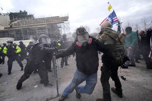 Trump supporters try to break through a police barrier, Wednesday, Jan. 6, 2021, at the Capitol in Washington. As Congress prepares to affirm President-elect Joe Biden's victory, thousands of people have gathered to show their support for President Donald Trump and his claims of election fraud. (AP Photo/Julio Cortez)


