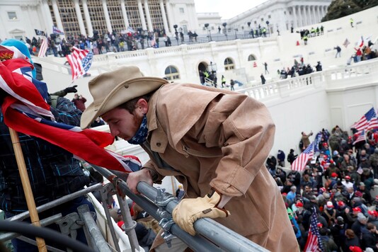 A protester climbs a barricade during clashes with Capitol police at a rally to contest the certification of the 2020 US presidential election results by the US Congress, at the US Capitol Building in Washington, US. (Reuters)
