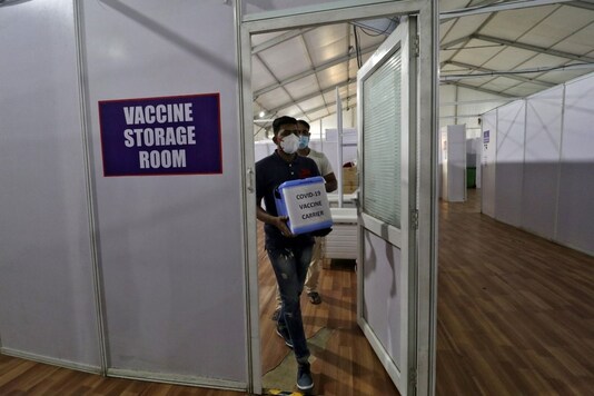 A healthcare worker carries a box during a preparation for a trial run of COVID-19 vaccine delivery systems, at a temporary vaccination centre in Mumbai. (Reuters)