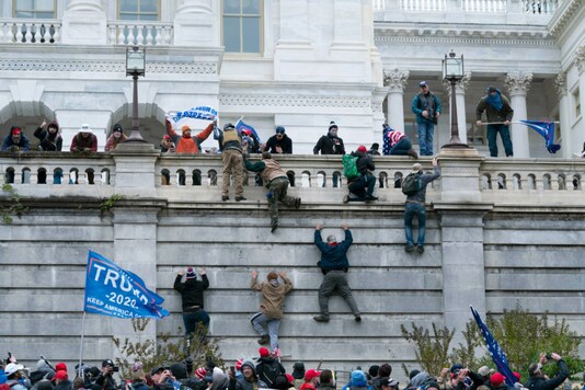 Supporters of President Donald Trump climb the west wall of the US Capitol on January 6, in Washington. (AP Photo/Jose Luis Magana)