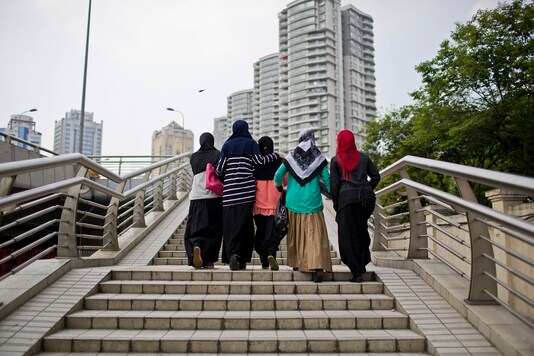Uighur women walk through downtown Shanghai. 