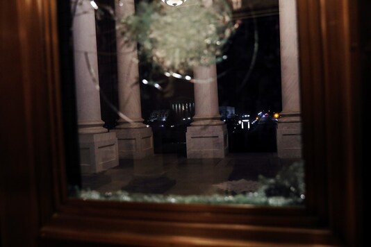 A view of the exterior is seen through the glass of a riot damaged door of the US Capitol in Washington, US. (Reuters)