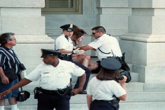 Capitol Police come to the aid of a wounded tourist after a gunman killed two officers inside an entrance to the US Capitol on July 24, 1998. (The New York Times/File Photo)