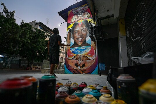 Street artist Wolfgang Salazar studies his mural honoring Venezuelan athlete Yulimar Rojas as he adds finishing touches, in the Boleita neighborhood of Caracas.

 (AP Photo/Matias Delacroix)