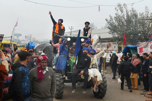 Protesters ride a tractor during an ongoing agitation over the new farm laws, at Singhu border in New Delhi on Friday. (PTI)