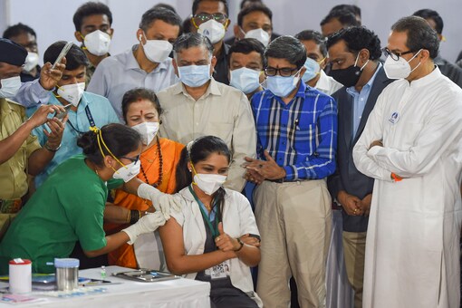 A medic administers the first dose of Covishield vaccine to Madhura Patil in the presence of Maharashtra CM Uddhav Thackeray on Saturday. (PTI)