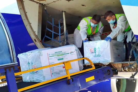 Health workers unload the first consignment of COVID-19 vaccine, in Indore. (PTI Photo)