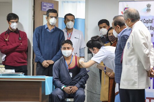 A medic administers the first dose of Covishield vaccine to a frontline worker in the presence of Union Health Minister Harsh Vardhan, after the virtual launch of COVID-19 vaccination drive by Prime Minister Narendra Modi, at AIIMS in New Delhi, Saturday, Jan. 16, 2021. (PTI Photo)