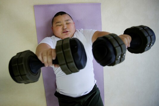 Kyuta Kumagai, 10, lifts dumbbells during a one-on-one training session which his father organized at the Buddhist temple Joshin-ji in Tokyo, Japan.

REUTERS/Kim Kyung-Hoon