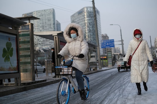 A woman wearing a face mask following the coronavirus disease (COVID-19) outbreak, rides a bicycle on the street during a snowy morning in Beijing, China, January 19, 2021. (Image: REUTERS) A woman wearing a face mask following the coronavirus disease (COVID-19) outbreak, rides a bicycle on the street during a snowy morning in Beijing, China, January 19, 2021. (Image: REUTERS)