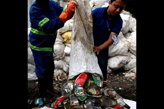 Workers from a recycling company dump garbage collected and brought from Mount Everest out of a bag, in Kathmandu. (Credit: REUTERS)