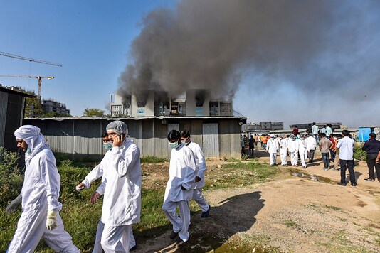 Workers of Serum Institute of India come out of the building after fire broke out in it, in Pune, Thursday, Jan. 21, 2021. (PTI Photo)