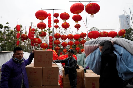 Workers move stock near lanterns on sale for the upcoming Chinese Lunar New Year in Wuhan in central China's Hubei province on Friday, Jan. 22, 2021. Life appears to be back to normal on the eve of the anniversary of the 76-day lockdown in the central Chinese city where the coronavirus was first detected. (AP Photo/Ng Han Guan)