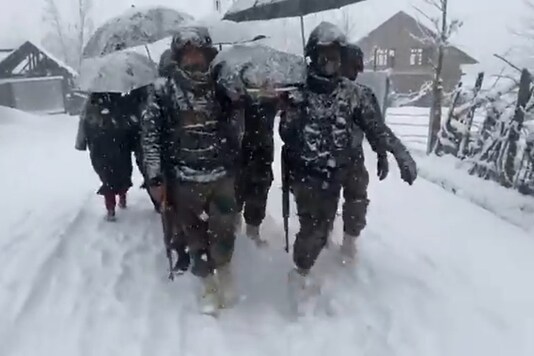 Indian Army ferry woman and her newborn on stretcher in Jammu & Kashmir's Kupwara district.