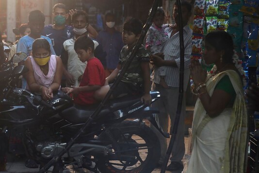 A group of children watch Tamil women cook special food to celebrate the harvest festival of Pongal at Dharavi, one of the world's largest slums, in Mumbai, India, Thursday, Jan. 14, 2021. (Image: AP)