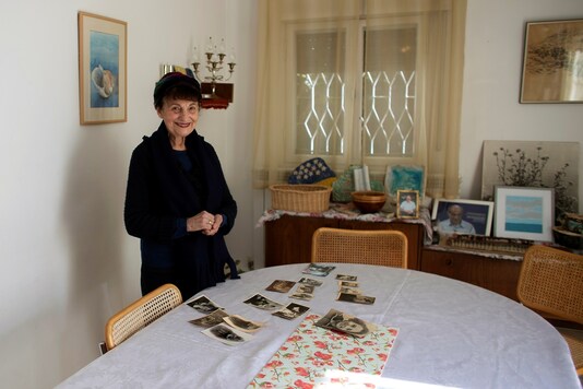 Holocaust survivor Leah Nebenzahl smiles near a collection of family photographs. REUTERS/Ronen Zvulun