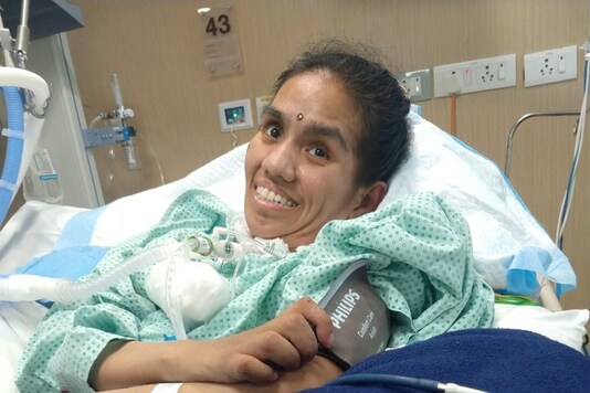 Poonam, now 33 years old, lies on her hospital bed. 