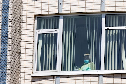 FILE PHOTO: A healthcare worker looks out of a window as healthcare workers, professionals and unions demanding safer working conditions and time off amid the coronavirus disease (COVID-19) outbreak protest in front of Santa Cabrini Hospital in Montreal, Quebec, Canada May 29, 2020. REUTERS/Christinne Muschi/File Photo