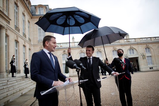 French President Emmanuel Macron holds an umbrella as Slovakia's Prime Minister Igor Matovic delivers a joint statement at the Elysee Palace in Paris, France, February 3, 2021. REUTERS/Benoit Tessier

