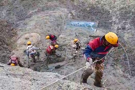 Rescue personnel rapple down to help trapped workers in a tunnel at Tapovan Dam.