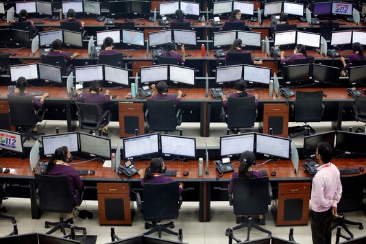 Employees wearing protective masks work inside a call centre run in Lucknow. (Reuters)