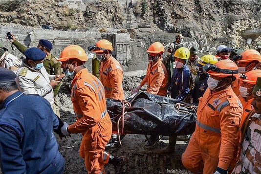 NDRF personnel carry the body of a victim who died in the massive floods caused after a glacier broke off in Joshimath in the Dhauli Ganga river in Uttarakhand. (PTI)
