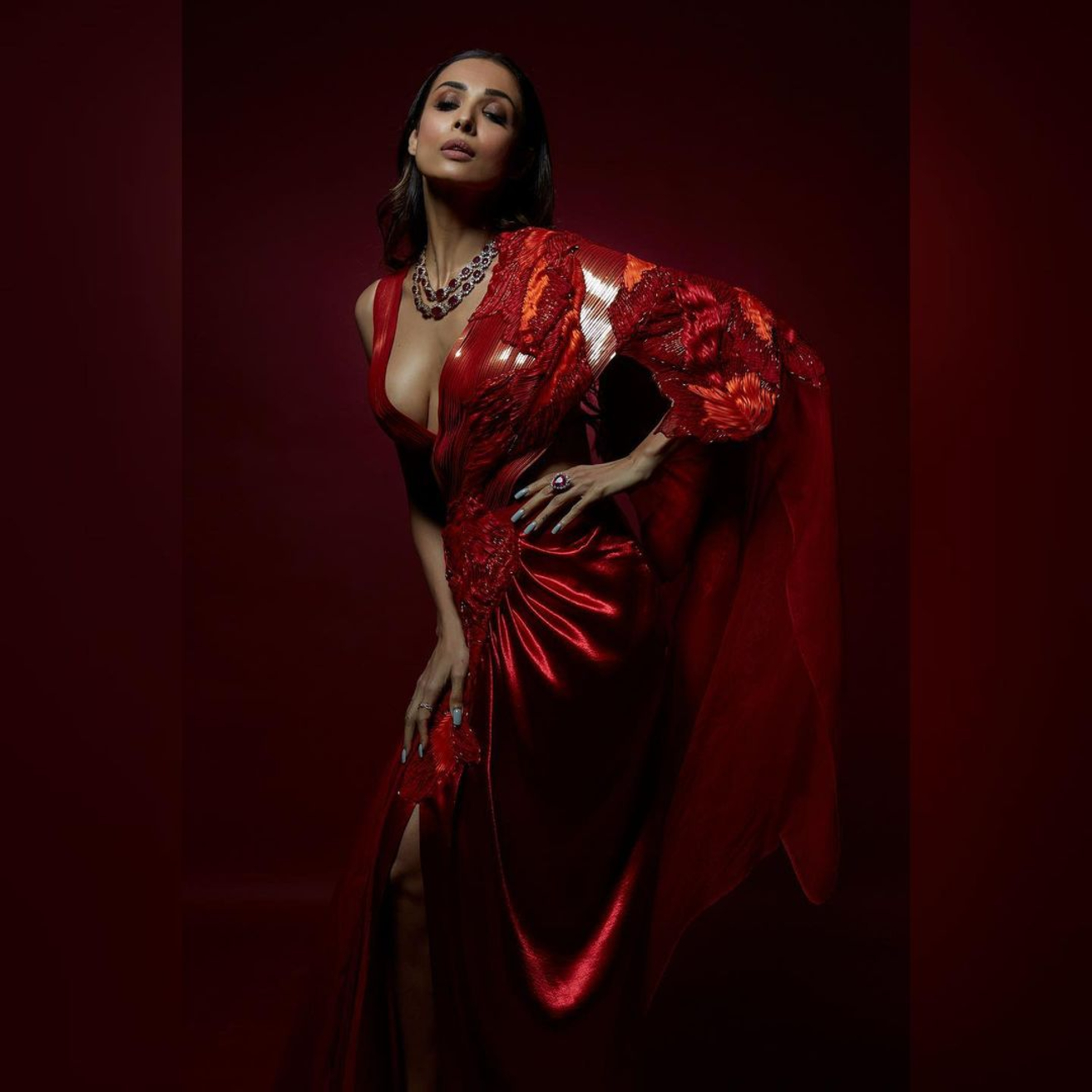  Malaika looks stunning in a crimson red saree as she poses for a bold photo, flaunting her cleavage. (Credit: Instagram)