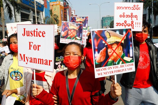 A protester holds a placard with an image of Myanmar military Commander-in-Chief Senior Gen. Min Aung Hlaing and Justice For Myanmar  (AP Photo)