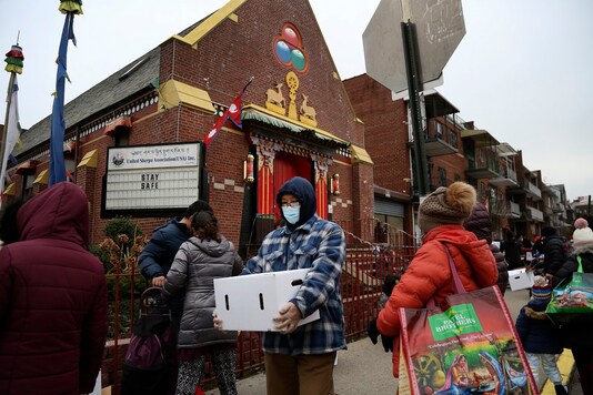 People receive free food from the United Sherpa Association's weekly food pantry in the Queens borough of New York. The pantry began in April with a focus on the Nepalese community, international students and families living in the country without permission. (AP Photo/Jessie Wardarski)