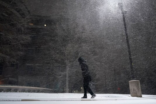 A woman walks through falling snow in San Antonio, Sunday, Feb. 14, 2021. Snow and ice blanketed large swaths of the U.S. on Sunday, prompting canceled flights, making driving perilous and reaching into areas as far south as Texas’ Gulf Coast, where snow and sleet were expected overnight. (AP)
