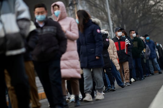 FILE PHOTO: People line up to get their nucleic acid test at a mass testing site following the outbreak of the coronavirus disease (COVID-19) in Beijing, China, January 22, 2021. REUTERS/Thomas Peter/File Photo