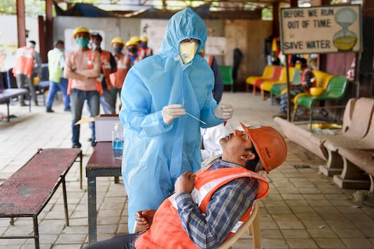  A health worker collects swab sample for the COVID-19 test. (PTI Photo)