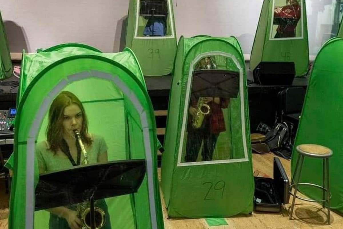 Dystopian Photo of School Band Rehearsing in Individual Crammed Tents