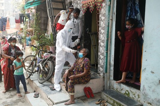 A healthcare worker collects a swab sample from a resident in Mumbai. (Reuters)