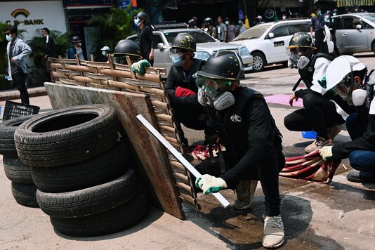 Demonstrators take cover during an anti-coup protest in Yangon, Myanmar, March 12, 2021. (Image: Reuters)