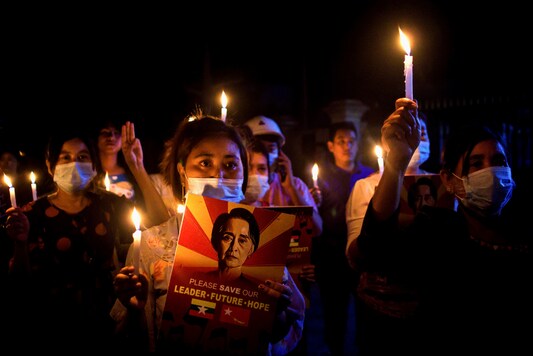 People hold candles during a nationwide night protest against the military coup.