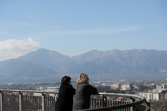 Women wearing protective face masks look at the view of the red zone town of Frosinone, as tighter restrictions have been introduced after an increase in coronavirus disease (COVID-19) infections, in Frosinone, central Italy, March 11, 2021. (Reuters)