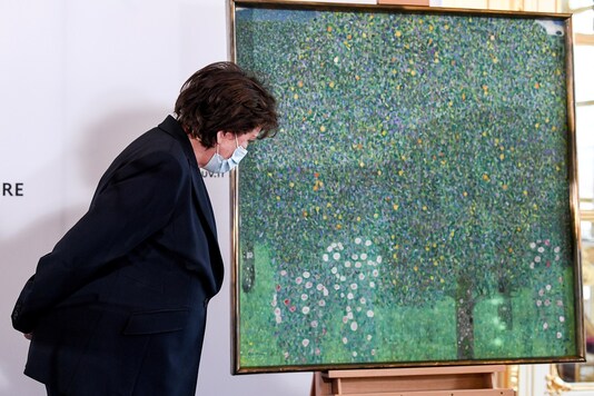 French Culture Minister Roselyne Bachelot stands next to the painting 