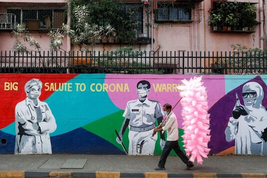 A man walks past a graffiti thanking Covid-19 warriors in Mumbai. (Reuters)