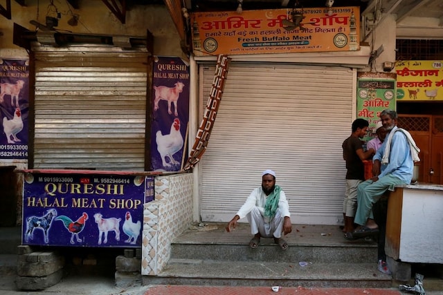 Representative image: People sit outside the closed meat shops in Gurugram, India, October 12, 2018. REUTERS/Adnan Abidi
