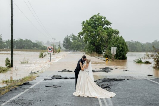 The Australian couple shares a kiss on the flooded bridge.
(Credit: Twitter/Kate Fotheringham
@KatelFog)