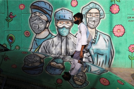 A boy walks past a coronavirus graffiti in New Delhi. (Reuters)