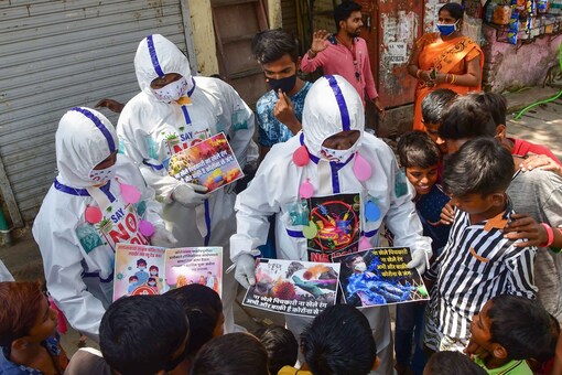 Social workers  distribute pamphlets among residents of Dharavi slums during an awareness campaign on not to celebrate Holi this year. (PTI)