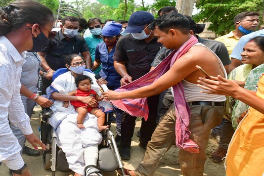 West Bengal Chief Minister Mamata Banerjee holds a child during her election campaign roadshow for Assembly polls, in Nandigram. (PTI)
